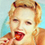 Pixelated close-up of a person with light brown hair styled in a retro updo, wearing red lipstick and a light-colored garment against a pale blue background.