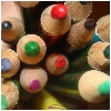 Close-up of multiple colored pencil tips arranged in a dense cluster, showing various colors including red, green, purple, blue, and brown.