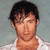 Pixelated image of a person with short dark hair wearing a light-colored shirt against a muted gray background.