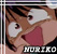 Pixelated close-up of a character with brown hair, wide eyes, and an open mouth showing teeth, wearing a red garment against a light background.