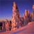 Pixelated landscape with tall central structure, blue sky gradient, and pinkish-orange terrain under low light.