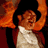 Pixelated static image of a person in motion with orange and brown tones against dark background, likely from a film or performance context.