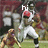 Pixelated image of a football player in white uniform holding a red helmet, with another figure on the ground nearby.