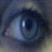 Pixelated close-up of a human eye with blue and gray tones, showing iris details and light reflection on the cornea.