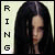A static pixelated image shows a person with long dark hair against a light background, with vertical text on the left side.