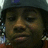A person wearing a gray helmet and red clothing appears in three showing subtle facial expression changes