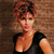 Pixelated image of a person with short brown hair wearing a black sleeveless top against a brown textured background.