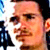 Pixelated static image of a person's face with visible facial features and partial background elements.