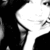 A high-contrast black-and-white pixelated image shows a partial profile of a person with dark hair and a light-colored shirt against a solid background.