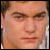 Pixelated close-up of a person's face with light brown hair, neutral expression, and visible eyes, nose, and mouth against a blurred background.