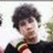 A pixelated image of a person with dark curly hair wearing a black top, with pink text reading 'Cassie Luvs Nick Jonas' overlaid on the right side.