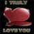 A pixelated red heart with a white highlight on a black background, flanked by pixelated text reading 'I TRULY' above and 'LOVE YOU' below.