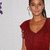 A static image shows a person in a red sleeveless top against a light gray background with partial purple and white pixelated elements on the left.