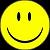 A static yellow circular icon with two vertical black oval eyes and a wide black curved smile on a dark background.