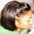 A person with dark shoulder-length hair in a green top, shown from the side across where their head turns slightly left to right