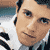 Static 50x50 pixel icon showing a close-up of a person's face with light skin tone, dark hair, and formal attire against a blurred background.