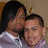 Two people in a close pose with one person's head resting on the other's shoulder, wearing light purple shirts with white collars.