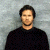 A pixelated image of a person in dark clothing against a light background, with green text reading 'Original Icons .com' on the right side.