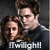 Two people in close proximity with dark hair, one wearing a dark shirt with 'Twilight' text, against a dark background.