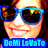 Pixelated close-up of a smiling person wearing blue-framed sunglasses with dark lenses and red hair, below which is text reading "DeMI LoMaTo" in light blue letters on a solid blue background.