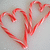 Two red candy cane-shaped hearts on a light gray background, with red pixelated text reading "all i want for christmas is love" and a small red heart symbol.