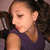 A person with curly hair in a high ponytail wears a sleeveless purple top, shown in three with slight head movement