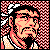 Pixelated static icon of a man's face with black hair and beard, rendered in red, white, and beige tones against a checkered background.