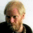 A static image shows a person with light hair and a beard on the left, with multiple 'DOOMED!' text elements in bold black and white lettering across the right and bottom.