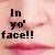 Pixelated text reads 'In yo' face!!' over a soft pink and white gradient background with subtle red accents.