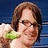 Pixelated image of a person with brown hair holding green foliage against a blue background.