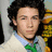 A pixelated image shows a person with dark curly hair wearing a light-colored jacket over a blue shirt and green bow tie, next to a teal speech bubble reading "OMJ I'M IN LOVE" in white text.