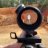 A static icon shows a dark cylindrical object with a circular lens-like top and a small square attachment on its side, set against a blurred background of brown and green tones.