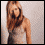 A woman with long brown hair in a gray tank top stands against a light background with scattered black stars, her head turning left to right across frames.