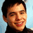 Pixelated image of a person with short dark hair and a black turtleneck, split into four quadrants with pink and gray backgrounds and text overlays.