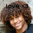 Pixelated image of a person with curly brown hair and light skin, wearing dark clothing against a gradient background.