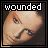Two side-by-side pixelated images of a person's face with the word 'wounded' above each, one in white text and one in red text.