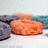 Pixelated orange fruit-shaped object on a white surface with blue and purple background elements.