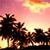 Pixelated sunset scene with dark silhouetted trees against a gradient sky transitioning from pink to yellow-orange.