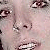 Pixelated close-up of a person's face showing eyes, nose, and mouth with light skin tones and dark hair, rendered in low-resolution digital style.