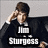 Pixelated image of a person with brown hair wearing a dark shirt, holding a hand near their face, with text reading "STUPIDNESS" below.