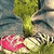 A static image of a character's lower body wearing blue jeans and red sneakers with white laces and soles, positioned against a green grassy background.
