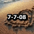 A pixelated image of a sandy beach with footprints and the date "7-7-08" overlaid in white text with black outlines, displayed in a