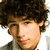 A pixelated image of a person with curly brown hair on the left, next to purple and gray containing yellow text