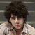 A four- shows a person with curly hair in a light-colored shirt against a gray striped background, with purple text overlays changing