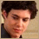 A pixelated image shows a person with dark hair on the left and a dark background with light text on the right.