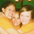 Two people in a yellow shirt pose closely together against a green background with visible pixelation.