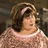Pixelated image of a woman with brown hair and a pink headband wearing a light pink sweater, with pink text on a black background reading 'That'll be five dollars Mrs Pingleton' and 'That seems like a lot for a pair of pettipants. with a rock'