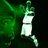 Pixelated green and white figure in dynamic pose against dark background, arms raised, one leg extended.
