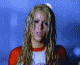 Britney Spears in a red-and-white raglan shirt with a graphic, performing dynamic poses against a blue background.