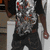 A person in a black t-shirt with silver and red patterns stands against a light background, shifting stance between frames.